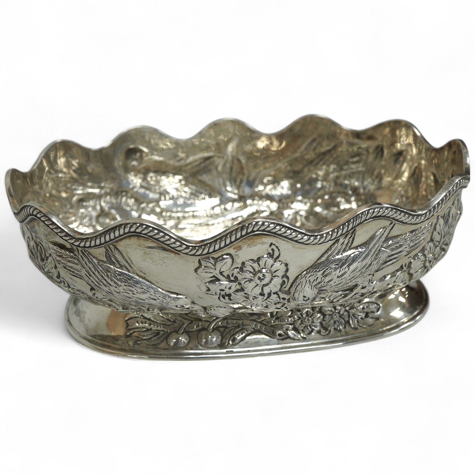 A late Victorian embossed silver oval bowl, decorated with birds, fruit and foliage, Charles Stuart Harris, London, 1889, length 14.3cm, 5.6oz.